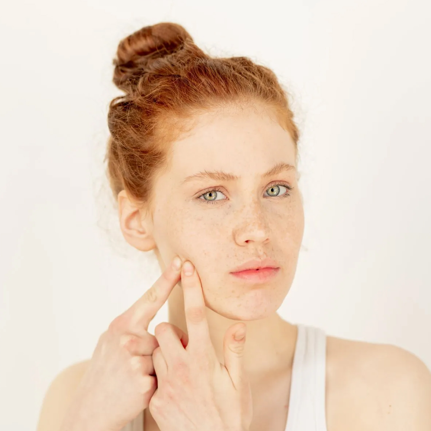 Young woman examining her skin