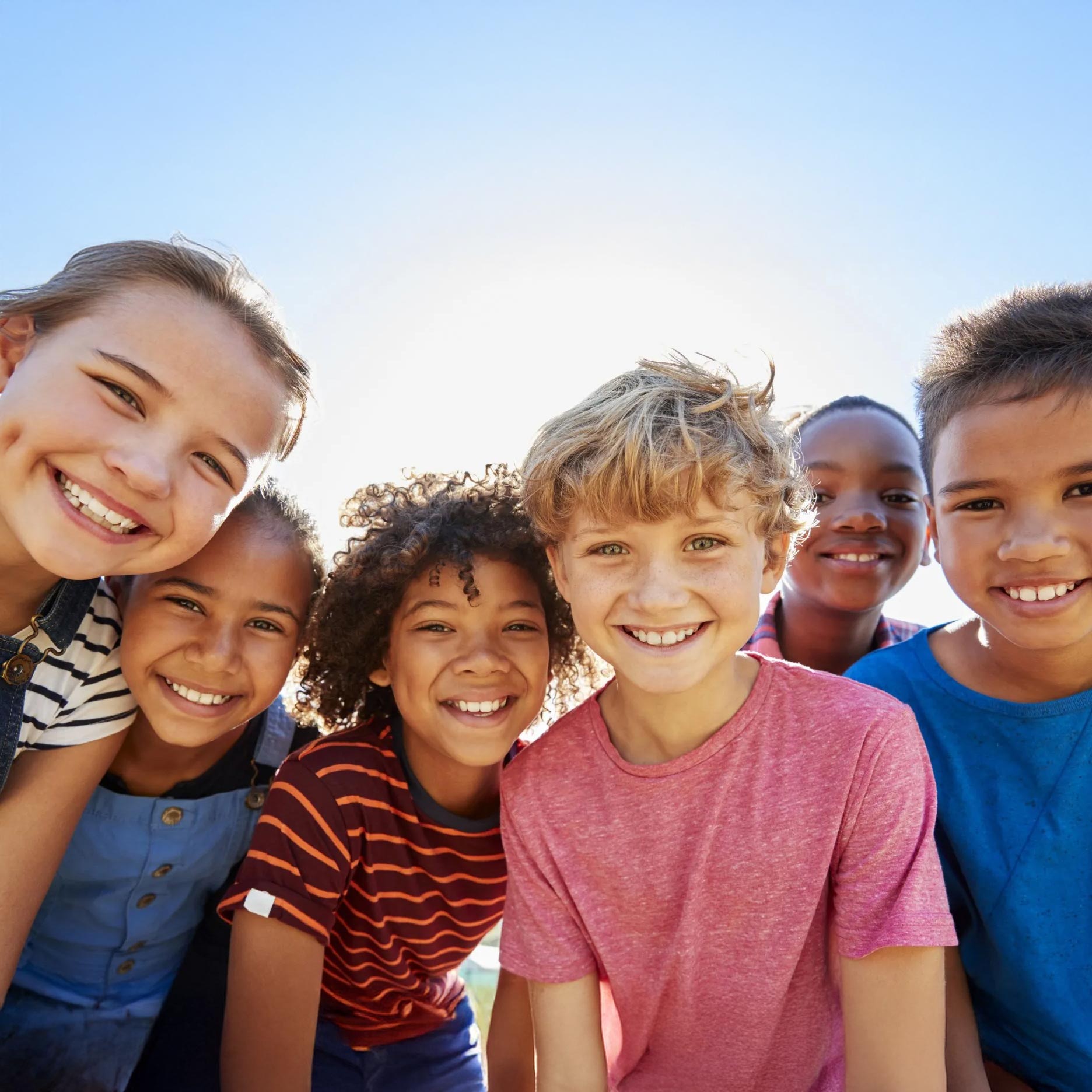 Group of smiling children outdoors.