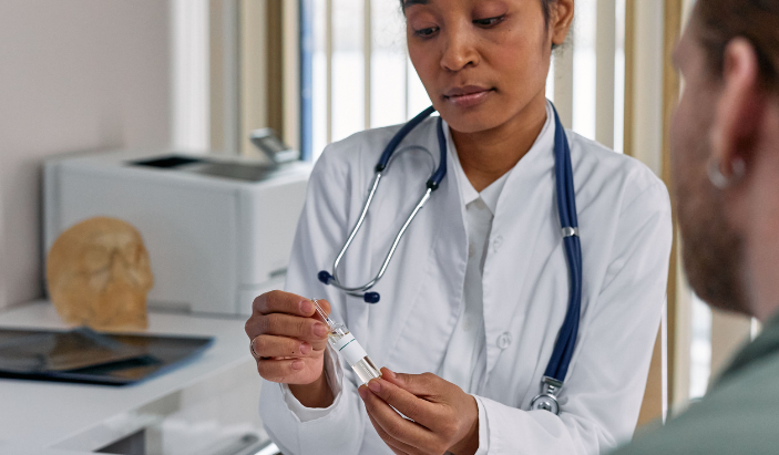 A female dermatologist in a white coat explaining prescription biologics and targeted treatments to a patient in Chattanooga, Tennessee.