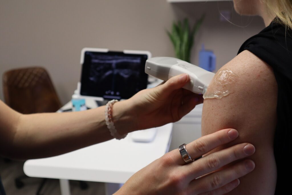 A board-certified dermatologist at a Chattanooga skin clinic using an advanced screening device on a patient's upper arm.