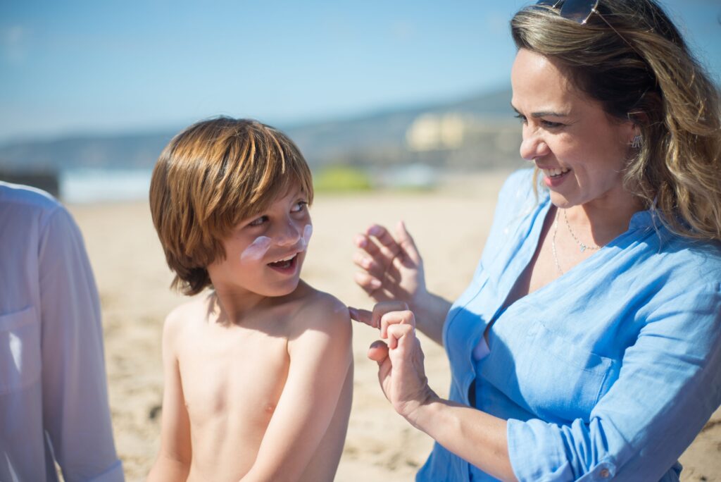 Parent applying skin protection to child before swimming to prevent chlorine skin irritation
