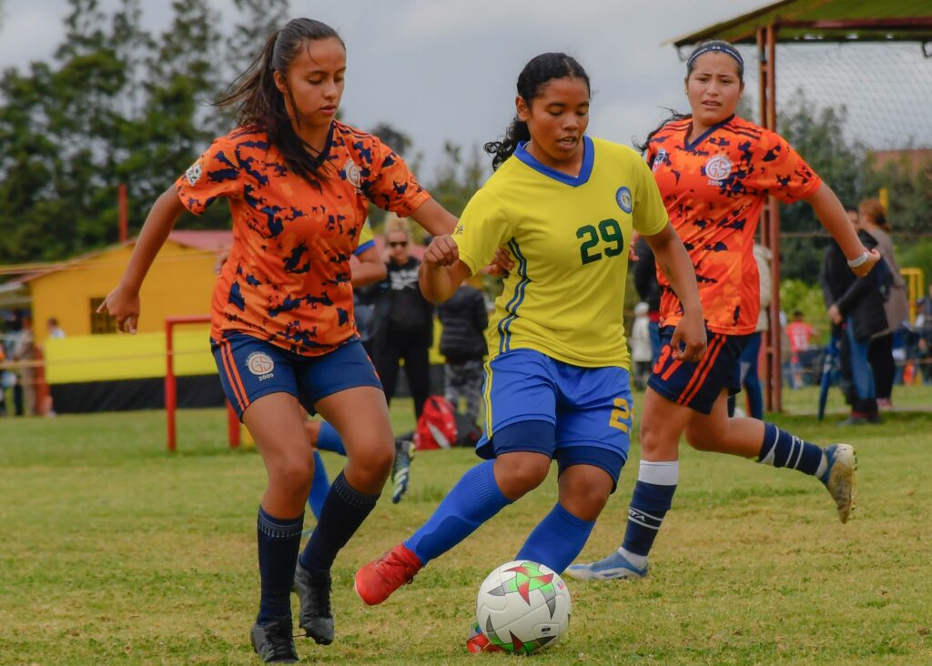 Teen athletes playing soccer in summer heat where sweat and friction can cause sports acne