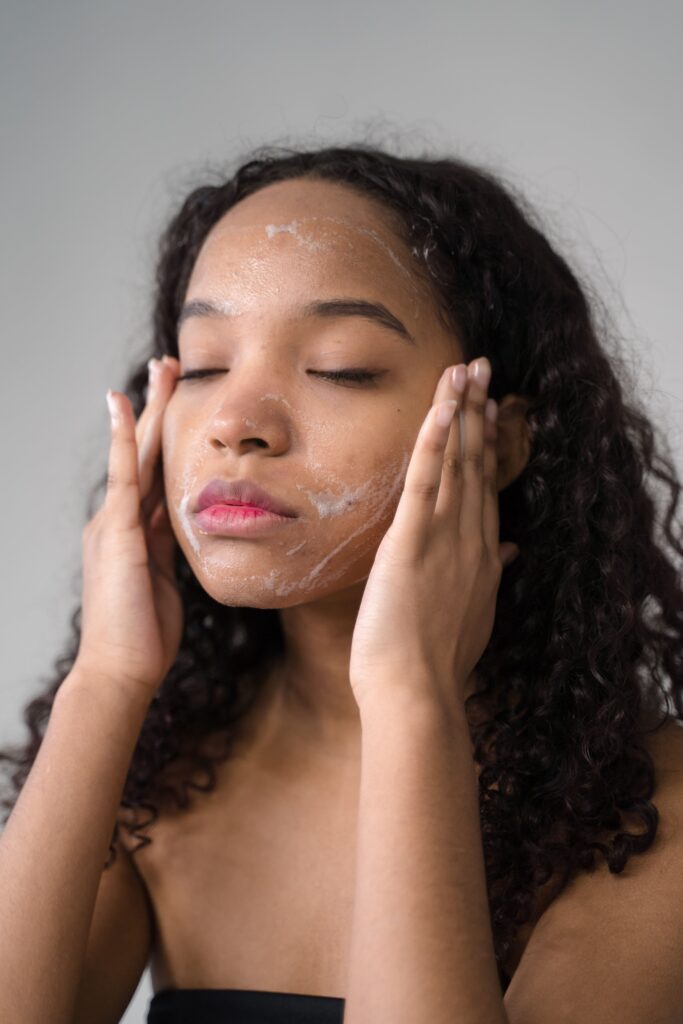Teen washing face with gentle cleanser to manage sports acne after summer practice