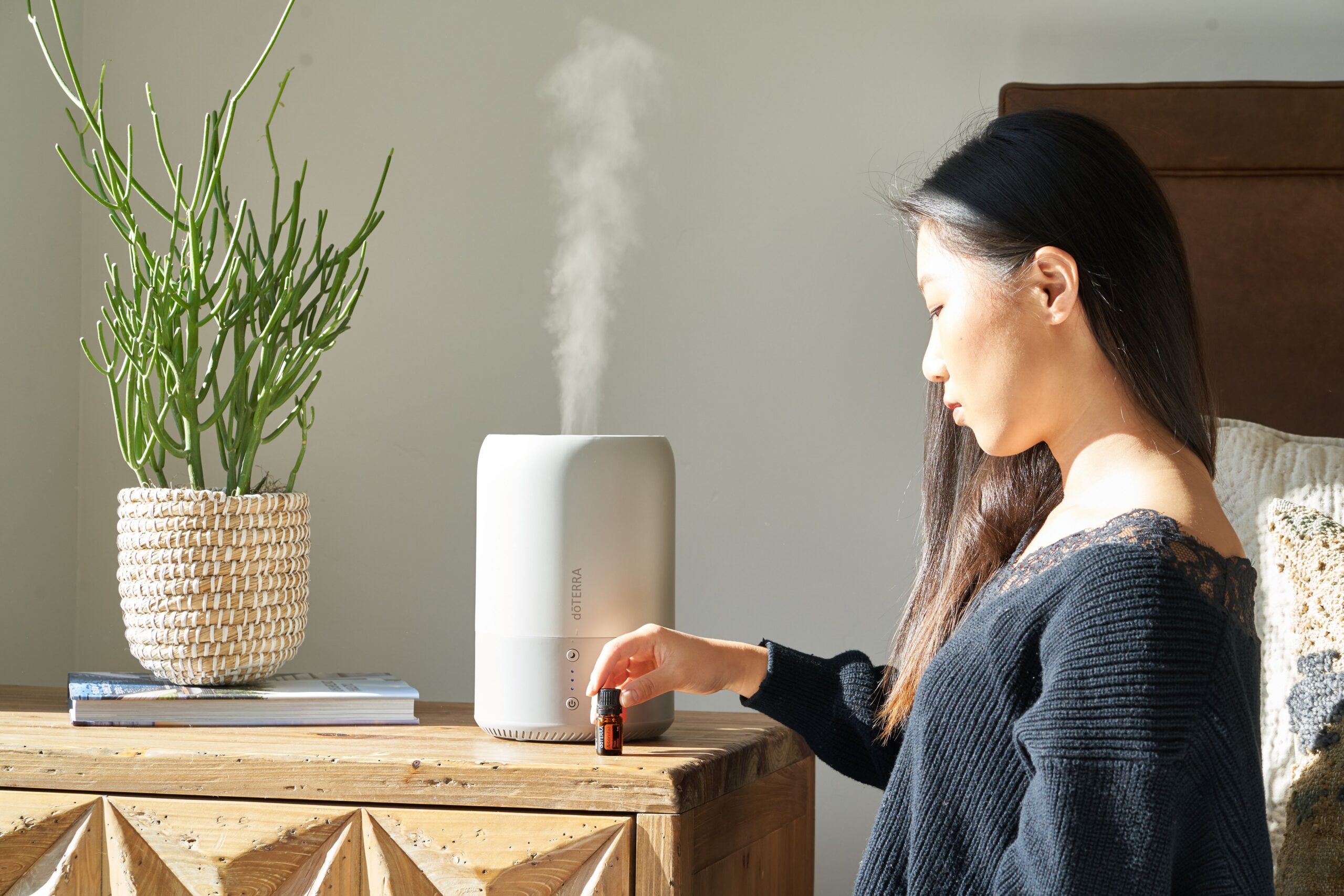 Woman using a humidifier at home to help manage dry skin in fall