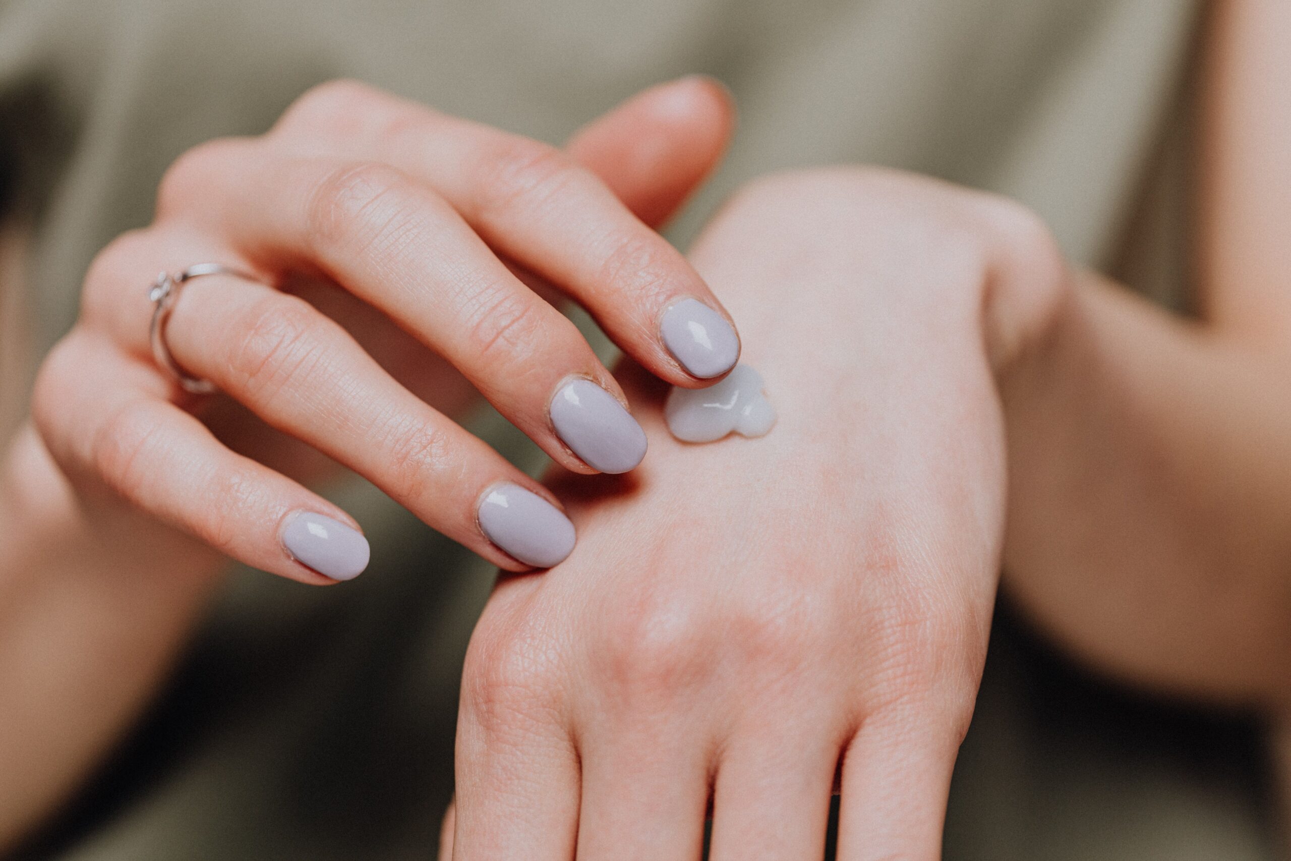 Applying moisturizer to dry hands as part of a fall skin care routine in Kimball TN